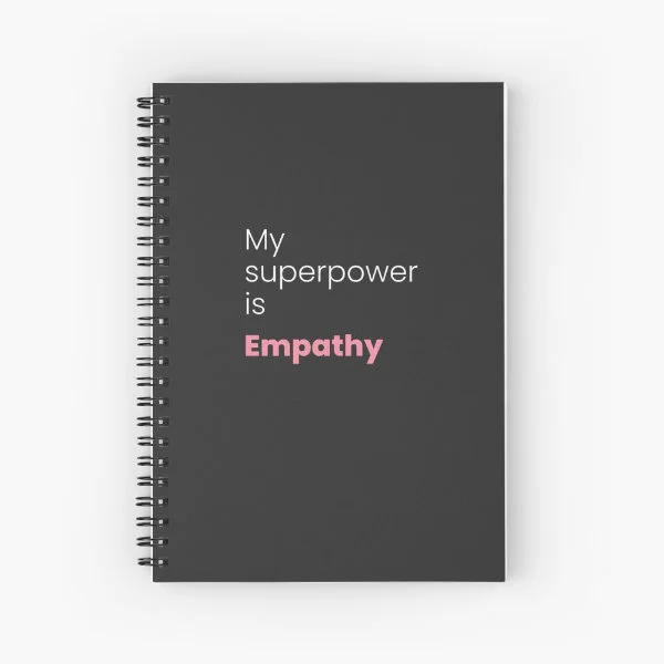 A spiral notebook with the phrase "My superpower is empathy" in white and pink letters.