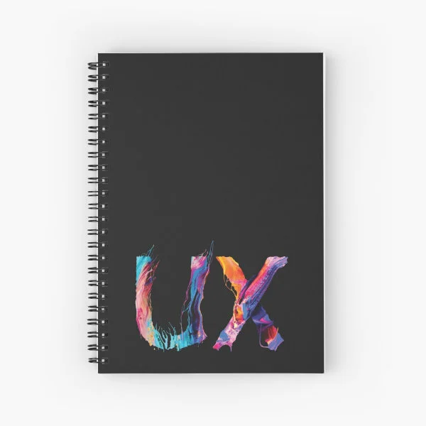 A spiral notebook with the letters "UX" in paint.